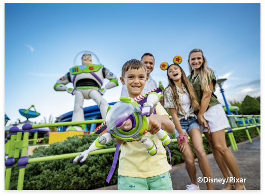 Boy Buzz Lightyear Toy flying in front of Buzz Lightyear Statue.